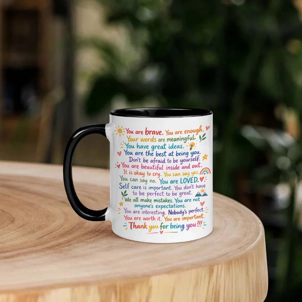 White mug with black interior and handle on a wooden surface.