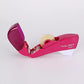 Pink tape dispenser with a roll of tape on a white background