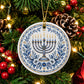 Blue and white Hanukkah ceramic ornament featuring a menorah and floral design