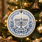 Blue and white menorah ornament hanging on a decorated Christmas tree