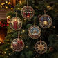 Five round beaded Christmas tree ornaments with intricate holiday scenes hang on a decorated Christmas tree. The ornaments feature detailed beadwork in red, gold, blue, green, and white, depicting a candle, a lantern, a gift box, a snowy house, and a star.