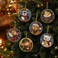 Six round Christmas diamond painting ornaments featuring penguins, a cat in a stocking, an angel, an elf, a dog, and a bear, hanging on a decorated Christmas tree with warm holiday lights.