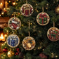 A set of round, beaded Christmas ornaments hanging on a decorated Christmas tree. The ornaments feature festive designs including gift boxes, a stocking with a teddy bear, a blue present, a wrapped package, and a teddy bear with a red bow, all embellished with gold-toned beads and rhinestones against a warm, blurred holiday background.