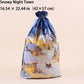 A clear plastic Christmas gift bag with a blue drawstring and a printed winter village scene, shown on a plain beige background with text reading 'Snowy Night Town' and dimensions at the top.