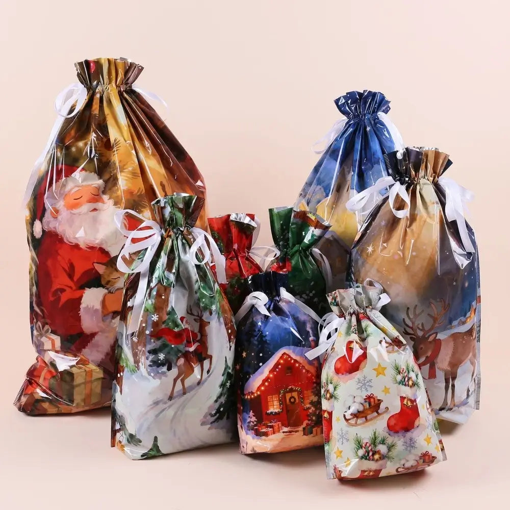 A set of Christmas-themed drawstring gift bags with various festive prints including Santa Claus, reindeer, a snowy house, and a sleigh, arranged together on a solid light beige background.