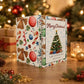 A spiral-bound Christmas gift card book standing on a wooden table, decorated with festive illustrations including a Christmas tree, ornaments, candy canes, and bows. The front cover reads 'Merry Christmas! A gift card book made just for you!' with a photo of a decorated Christmas tree.