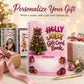 A spiral-bound pink 'Holly Jolly Gift Card Book' stands on a tabletop with holiday-themed wrapping paper, presents, ornaments, and a gold pen around it. Large text at the top reads 'Personalize Your Gift' with smaller copy below.