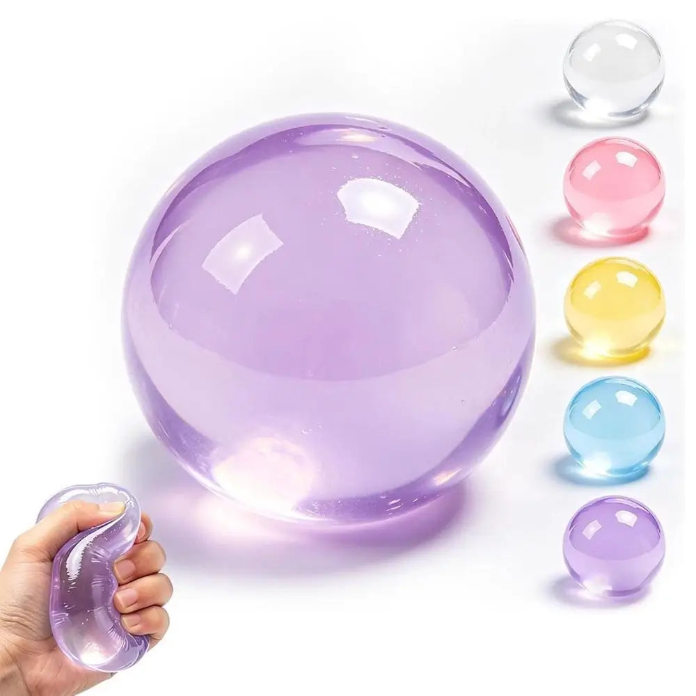 A translucent purple stress ball being squeezed by a hand, with five smaller color variants lined up on the right: clear, pink, yellow, blue, and purple. The main ball is lavender purple, and the hand demonstrates its squishy texture.