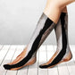 Gray furry dog leg socks worn on walking legs against a white wall and light wood floor
