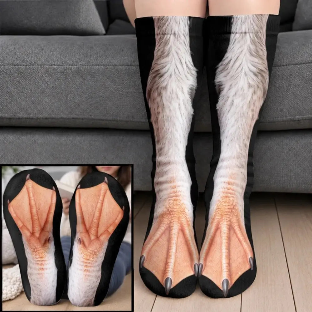 White feathery duck webbed foot socks worn on legs before a gray sofa with a sole closeup