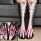 White and pink furry monster claw socks with pink webbed toes worn on legs before a gray sofa