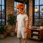 A man wearing a plush orange dinosaur head and tail costume stands in a modern loft-style room with brick walls, large windows, and indoor plants.