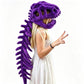 A woman wearing a plush purple dinosaur skull helmet with a long matching tail, posed against a plain white background.