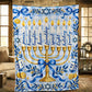 The Hanukkah blanket with a golden menorah and blessing words lies over furniture in a rustic stone walled room