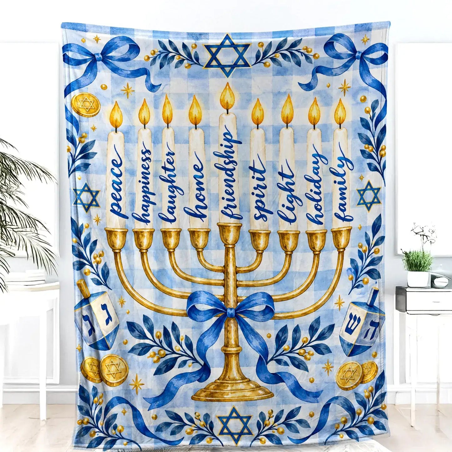 The Hanukkah blanket with a golden menorah and two dreidels hangs as a decorative wall piece against a white wall