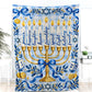 The Hanukkah blanket with a golden menorah and two dreidels hangs as a decorative wall piece against a white wall