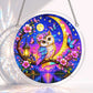 A round acrylic suncatcher with a colorful owl on a blossoming branch under a crescent moon butterflies and a lantern