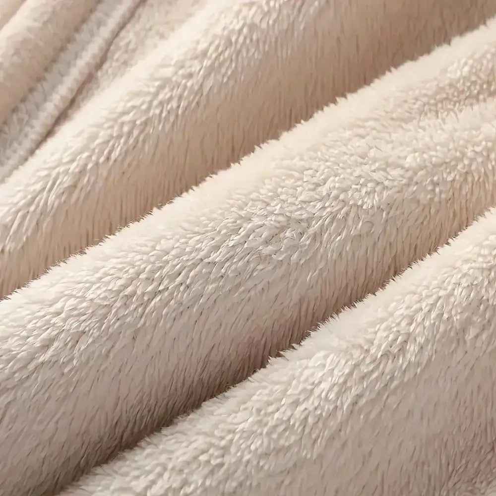 Close-up of a soft plush fabric in a warm off-white or cream color, showing the texture and folds of the material.