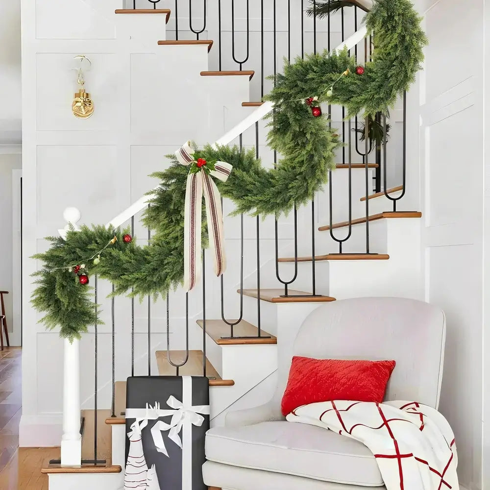 Decorative Christmas garland on a staircase with a white chair and gift bag in the foreground.