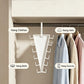 A white triangular hanging organizer rack shown inside a closet, with labeled callouts for hanging clothes, hats, belts, and scarves. Several garments are hanging on the right side.