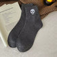 Halloween crew socks featuring an embroidered skull motif