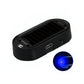 A black oval-shaped electronic device with a ribbed top surface, shown on a white background with a circular inset demonstrating a blue light effect.