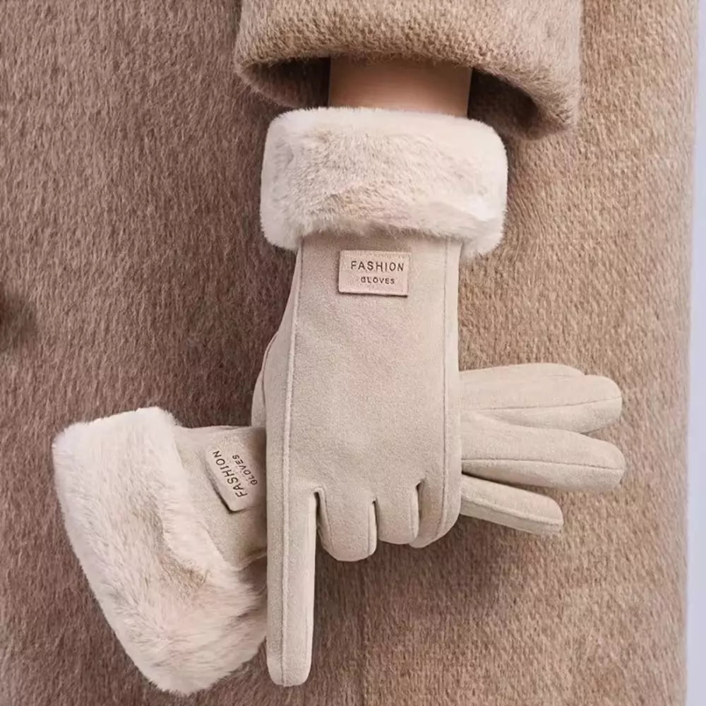 A pair of beige faux-suede winter gloves with fluffy cream faux-fur cuffs, shown on a model wearing a matching beige coat. 