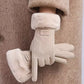 A pair of beige faux-suede winter gloves with fluffy cream faux-fur cuffs, shown on a model wearing a matching beige coat. 