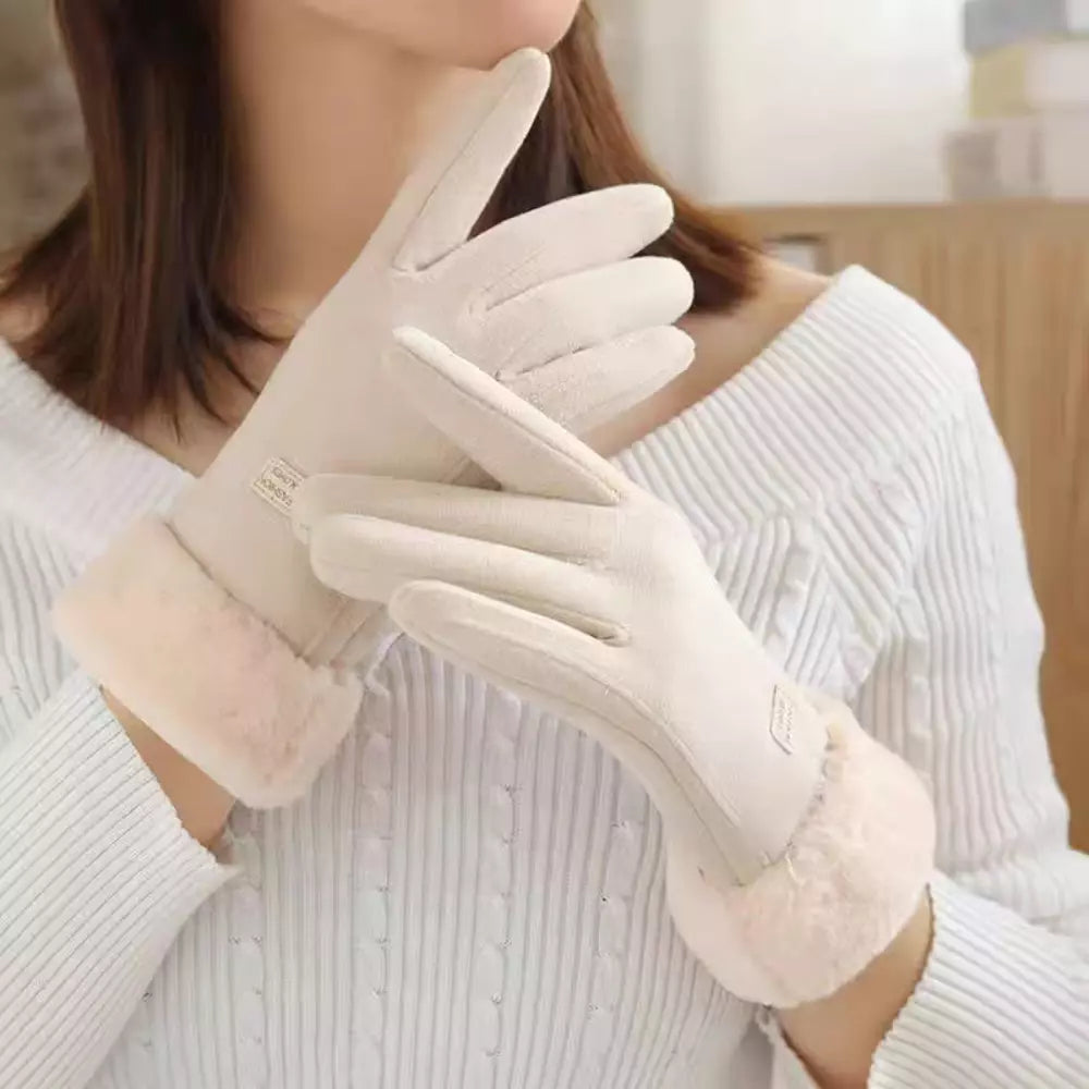 A close-up of a person wearing off-white winter gloves, paired with a white ribbed sweater.
