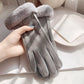 Gray glove with fur trim held by a hand on a light surface