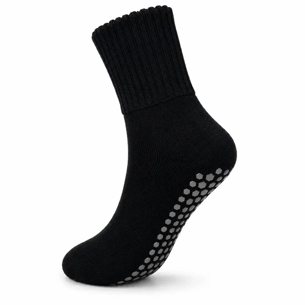 A single black ankle sock with gray non-slip grip dots on the sole, shown against a plain white background.